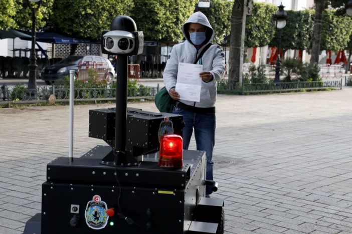 Khaled Nasraoui, A man shows a permit to a police robot monitoring curfew enforcement to curb the spread of COVID-19 in Tunis, April 2020